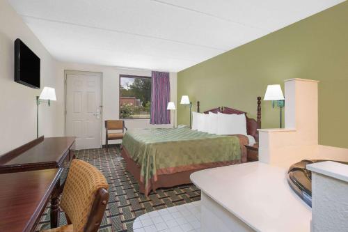 ein Hotelzimmer mit einem Bett und einem Schreibtisch in der Unterkunft Days Inn by Wyndham Eufaula AL in Eufaula