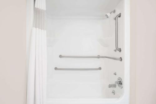 La salle de bains est pourvue d'une douche avec rideau de douche. dans l'établissement Days Inn by Wyndham Eufaula AL, à Eufaula