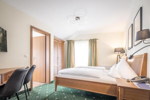 a hotel room with a bed and a desk at Hotel-Gasthof Höttl in Deggendorf