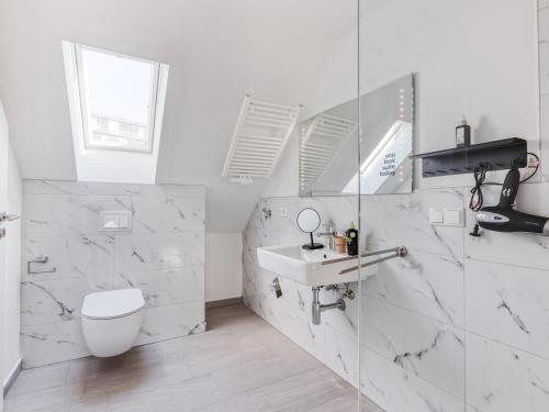a white bathroom with a toilet and a sink at Limehome Hannover Bleichenstraße - Digital Access in Hannover