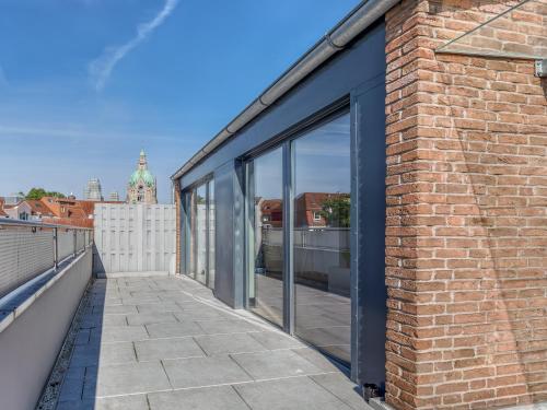 a brick building with glass windows on a balcony at Limehome Hannover Bleichenstraße - Digital Access in Hannover