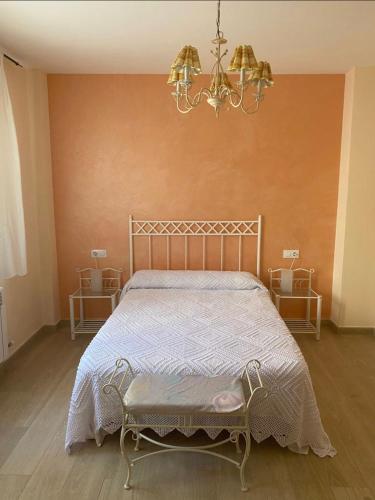 1 dormitorio con cama y lámpara de araña en Hostal Sara, en Villafeliche
