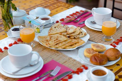 une table avec des assiettes de nourriture et des verres de jus d'orange dans l'établissement O'Atlas, à El Harkat