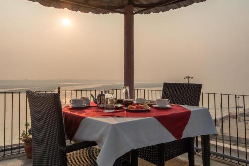 a table with a plate of food on top of a balcony at Amritara Suryauday Haveli in Varanasi