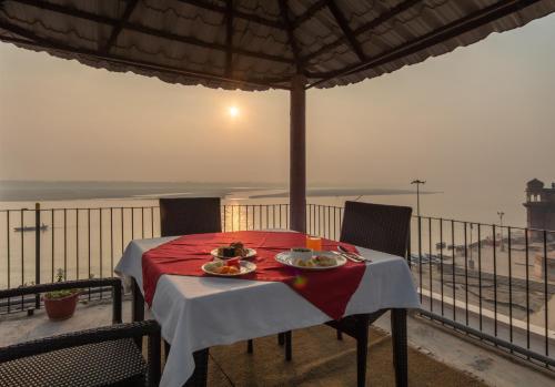 a table with plates of food on top of a balcony at Amritara Suryauday Haveli in Varanasi