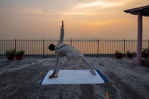 a man doing a handstand on a yoga mat at Amritara Suryauday Haveli in Varanasi