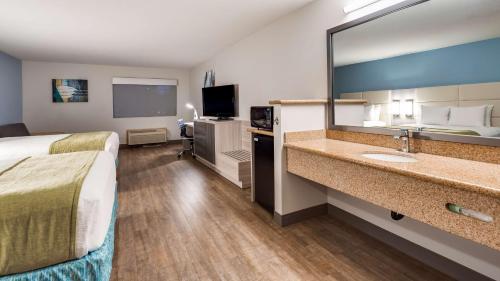 Sandyにあるベスト ウエスタン サンディー インのベッドと大きな鏡が備わるホテルルームです。