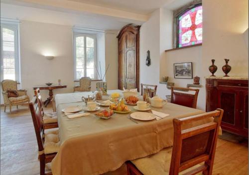 ein Esszimmer mit einem Tisch mit Essen drauf in der Unterkunft Maison d'hôtes Le Couvent in Bagnères-de-Bigorre