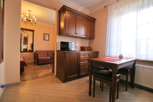 a living room with a table and a kitchen at Apartamenty Furta Dominikańska in Sandomierz