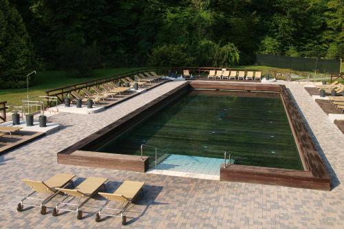 a large swimming pool with chairs and a group at Hotel Toplice - Terme Krka in Smarjeske Toplice