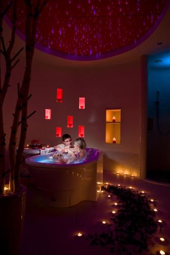 two people in a tub in a room with lights at Hotel Toplice - Terme Krka in Smarjeske Toplice