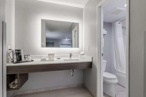 a bathroom with a sink and a toilet and a mirror at Quality Inn Kodak Sevierville in Kodak