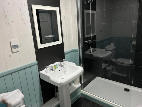 a bathroom with a sink and a shower and a toilet at South Lawn Hotel in Lymington