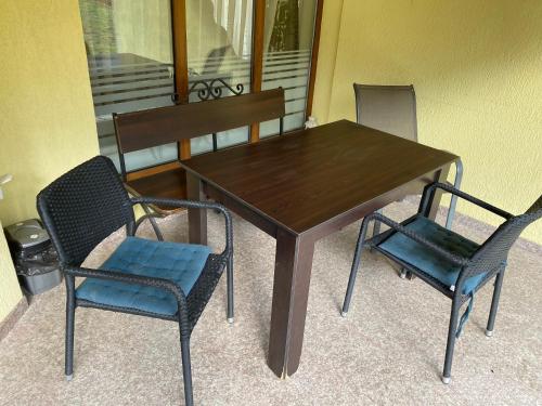 a wooden table with two chairs and a table and chairs at Kot Garden Guest House in Sapareva Banya
