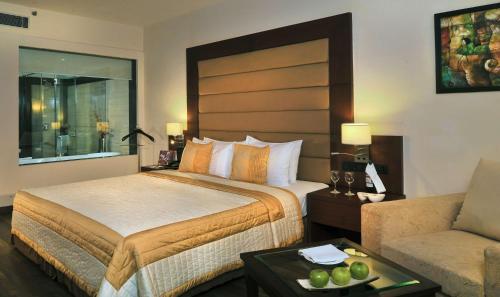 a hotel room with a bed and a couch at Country Inn & Suites by Radisson, Gurugram Sector 12 in Gurgaon