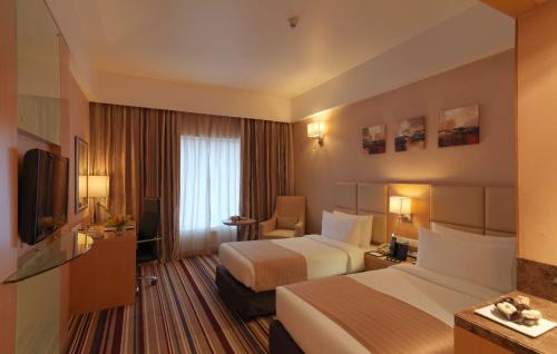 Habitación de hotel con 2 camas y TV en Mysore County Retreat, en Mysore