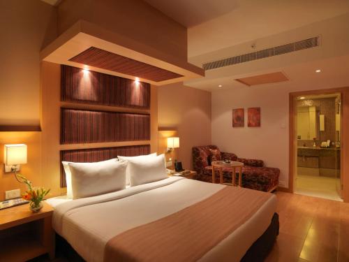 a hotel room with a bed and a chair at Mysore County Retreat in Mysore