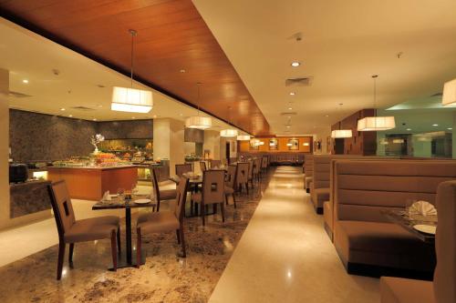 a restaurant with tables and chairs and a bar at Mysore County Retreat in Mysore