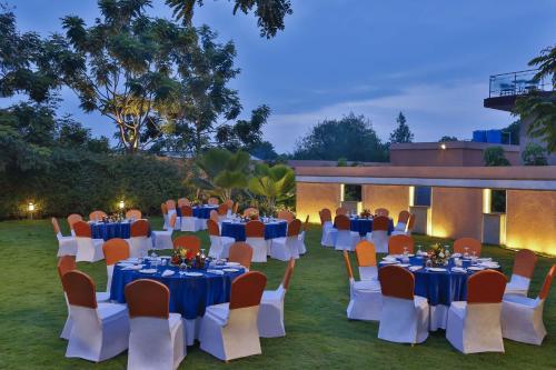 a group of tables and chairs in front of a building at Mysore County Retreat in Mysore