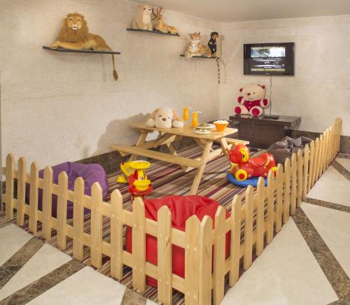 a room with a wooden crib with stuffed animals and a table at Mysore County Retreat in Mysore