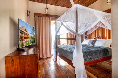 a bedroom with a canopy bed and a window at Cast Away Residence in Kiwengwa