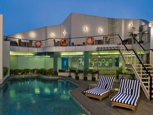 een hotel met 2 stoelen en een zwembad bij Park Inn by Radisson New Delhi IP Extension in New Delhi