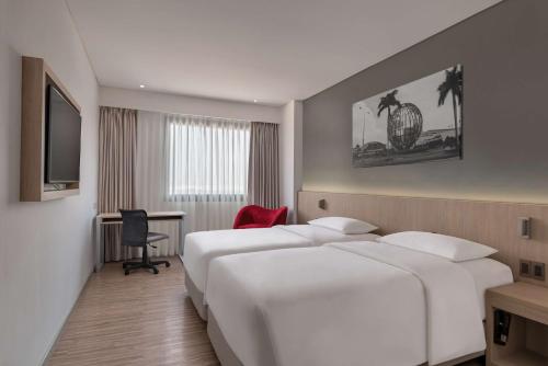 a hotel room with two beds and a desk at Park Inn by Radisson North Edsa in Manila
