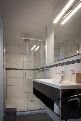 a bathroom with a sink and a shower with a mirror at Zur Krone in Neuötting