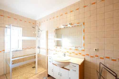 W łazience znajduje się umywalka, prysznic i lustro. w obiekcie Villa Isa - Heated Pool - Free wi-fi - Air Con w mieście Guia