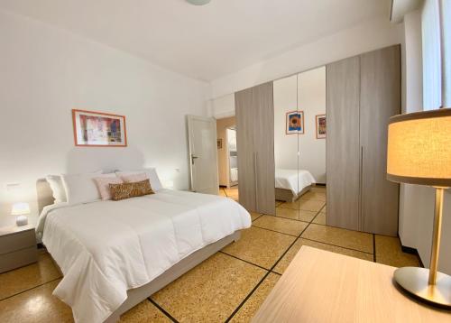 a bedroom with a large white bed and a table at CasaViva- Ampio e luminoso quadrilocale a Rapallo in Rapallo