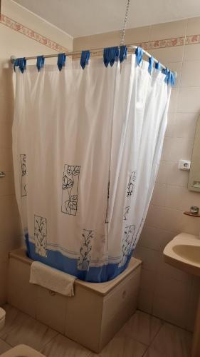 a bathroom with a shower curtain and a sink at Apartamentos El Valle in Frontera