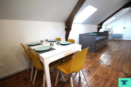 uma sala de jantar com uma mesa branca e cadeiras amarelas em La demeure du maréchal-ferrant em Pierry