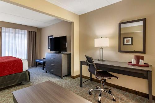 a hotel room with a bed and a desk with a computer at Comfort Suites Alpharetta-Roswell - Atlanta Area in Alpharetta