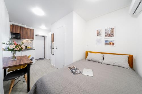 a bedroom with a bed and a desk with a laptop at MYFREEDOM Апартаменти метро Чернігівська Інститут Серця in Kyiv