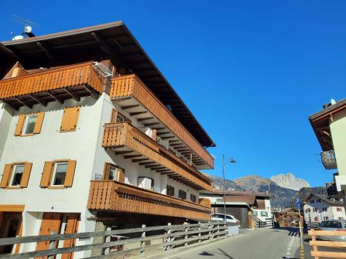 un edificio con balcones de madera en un lateral en Appartamento Casa Montagna Lory, en Pozza di Fassa