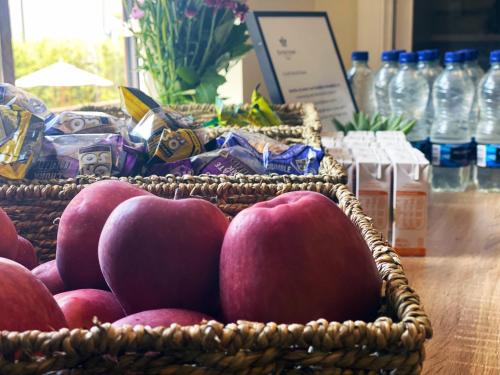 a basket of apples on a table with water bottles at Orchid Epsom; Sure Hotel Collection by Best Western in Epsom