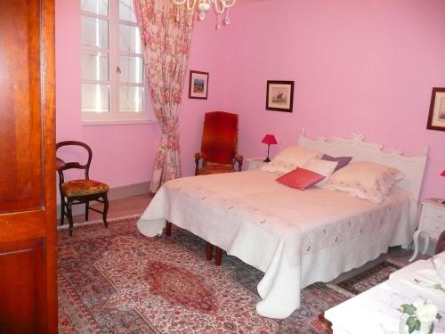 a bedroom with a white bed and a pink wall at Chambres d'Hôtes Saint Roch in Tournecoupe