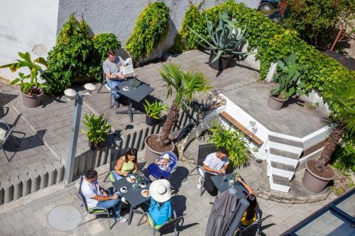 a group of people sitting at a table in a garden at Relax Hotel & SPA Stuttgart in Stuttgart