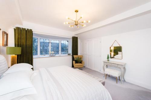 a white bedroom with a bed and a desk at The Tower by Harrogate Serviced Apartments in Harrogate