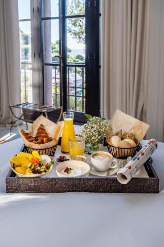 bandeja con alimentos para el desayuno y bebidas en una mesa en Soho Boutique Castillo de Santa Catalina - Adults Recommended, en Málaga