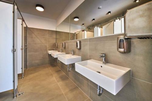 uma casa de banho com três lavatórios e uma fila de espelhos em Easyatent Camping Stella Maris em Umag
