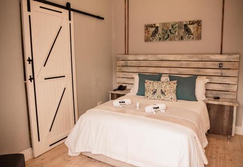 a bedroom with a white bed with a wooden door at The Perfect Corner Guesthouse in Bethlehem