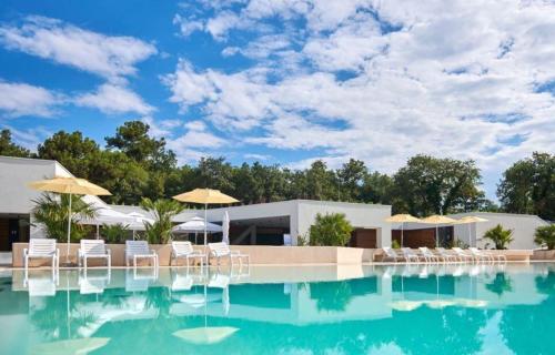 a swimming pool with chairs and umbrellas at Easyatent Camping Stella Maris in Umag