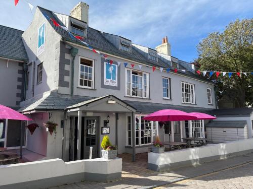a building with pink umbrellas in front of it at La Ville Hotel in Alderney