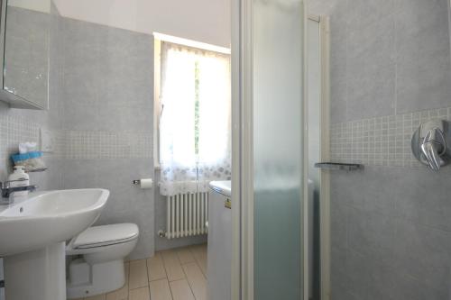 La salle de bains est pourvue d'un lavabo, de toilettes et d'une fenêtre. dans l'établissement Da Guido - Letizia, à Tignale
