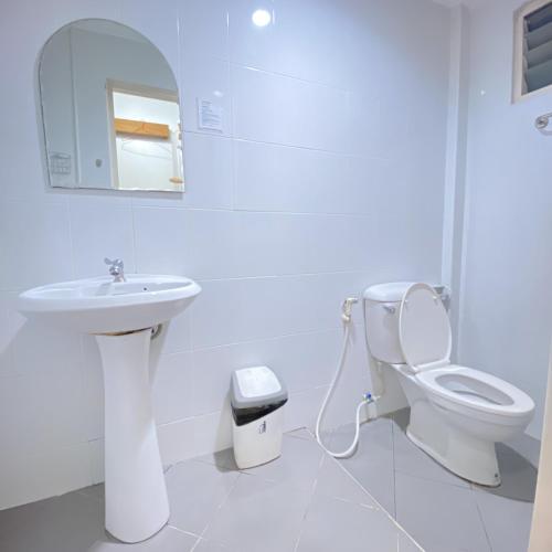 a white bathroom with a sink and a toilet at Bunk Boutique in Chiang Mai