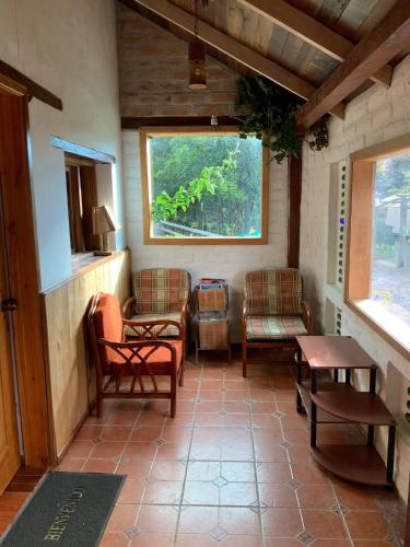 a living room with chairs and a table and a window at Hostal Mamá Hilda in Chugchilán