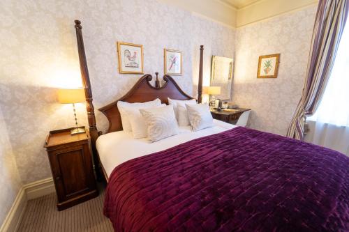 a bedroom with a large bed with a purple bedspread at Brooks Guesthouse in Bath