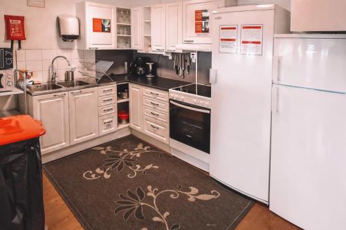 a white kitchen with a refrigerator and a sink at Abisko Guesthouse & Activities in Abisko