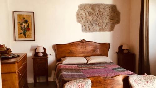 una camera con letto e testata in legno di B&B La Corte del Segrino a Canzo